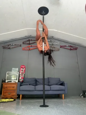 Tattooed Woman Spins and Inverts on a Pole