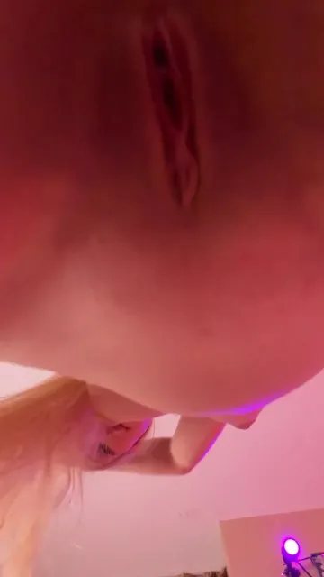 Blonde Poses Nude Above a Low Camera in Pink Light