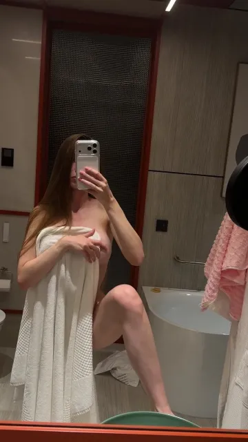 Woman Flashes in a Bathroom Mirror with a White Towel