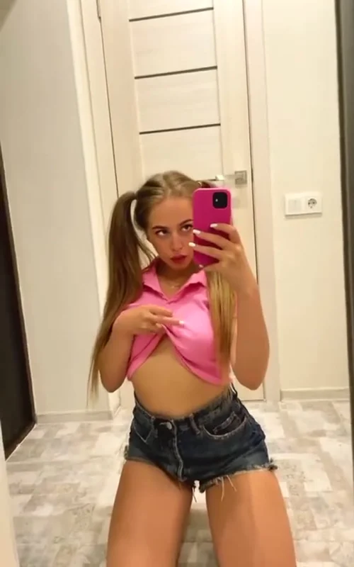 Blonde Takes a Mirror Selfie in a Pink Top