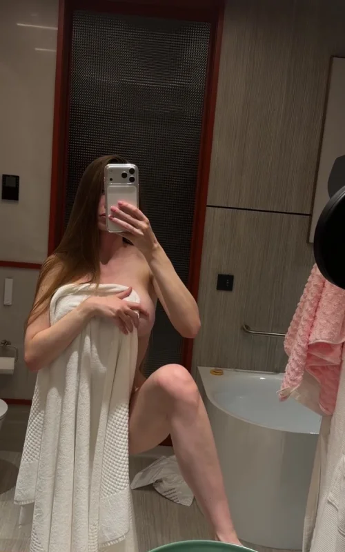 Woman Flashes in a Bathroom Mirror with a White Towel