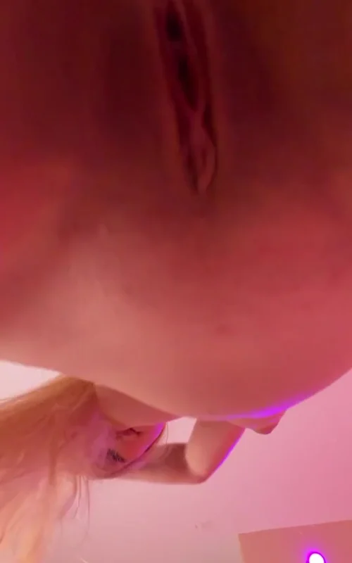 Blonde Poses Nude Above a Low Camera in Pink Light