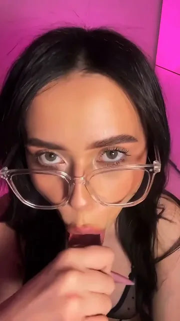 Brunette in Glasses Brings Toy to Mouth